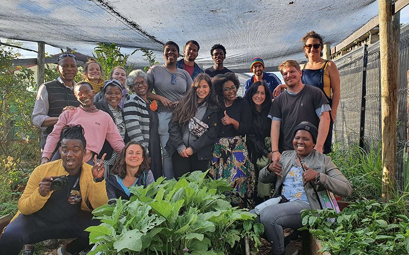 Group of people standing in a thriving greenhouse.