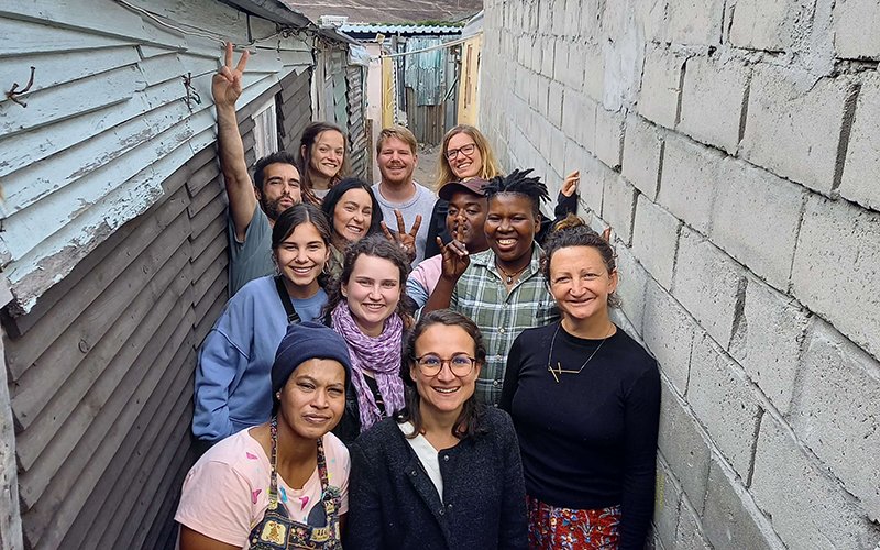 Group of people smiling in a small alleyway.