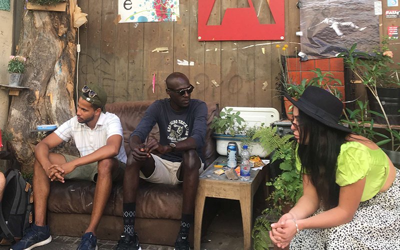 Three people sitting on chairs talking to one another.